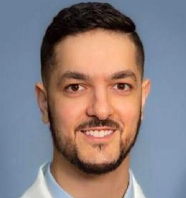 Professional headshot of Dr. Robert Peracchia, DDS, smiling against blue background.