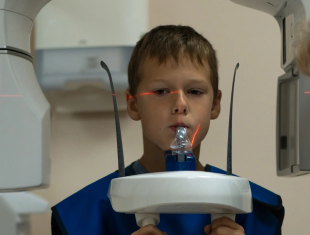 Young boy using nebulizer mask for dental treatment in pediatric dental office.