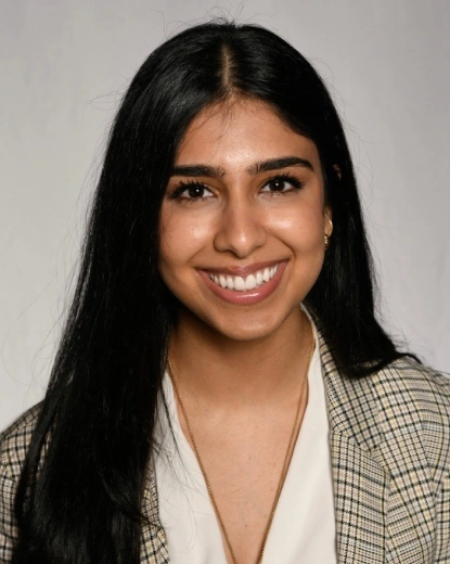 Professional headshot of a smiling woman in business attire against a neutral background.